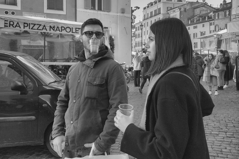 Straßenszene in Rom. Ein junger Mann mit Plastikbecher.